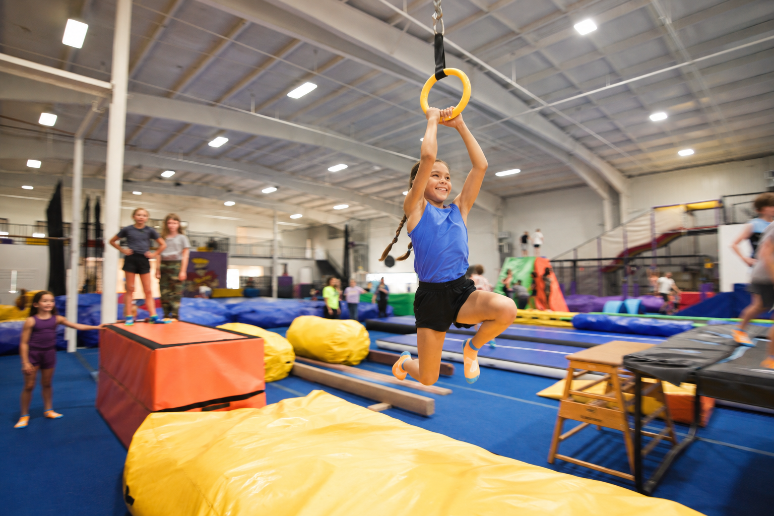 Child gripping a yellow obstacle ring above thick padding